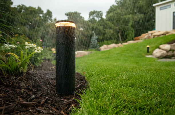 An outdoor speaker installation with a speaker mounted against a house.